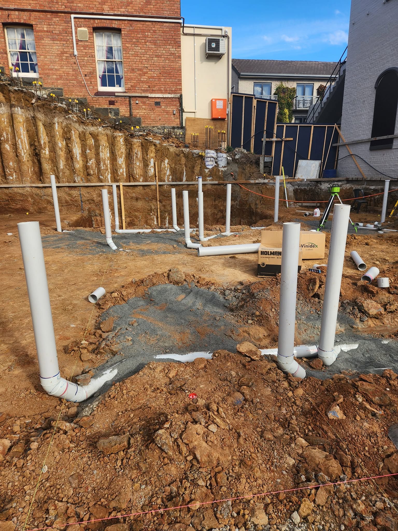 New-home plumbing stub-ups set into a prepared foundation