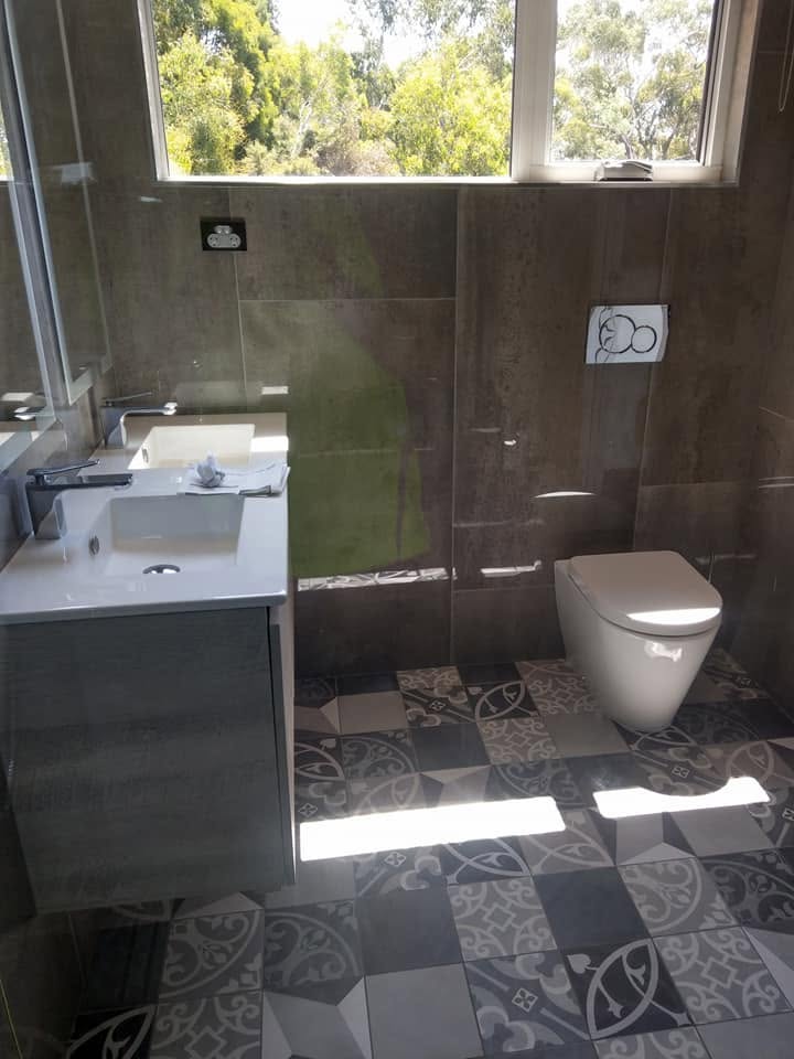 A finished bathroom with dark tiling