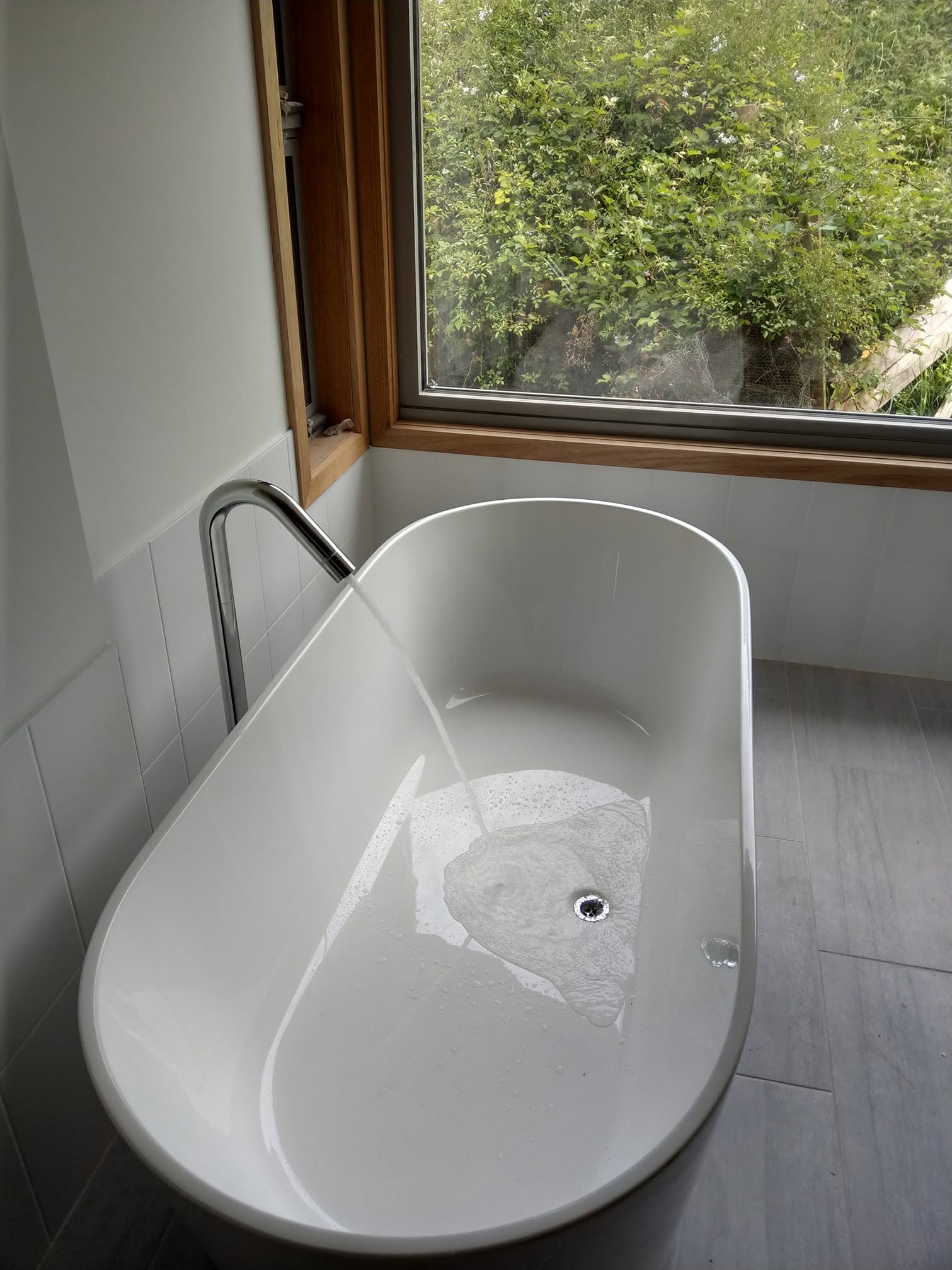 A freestanding bath in a completed bathroom renovation